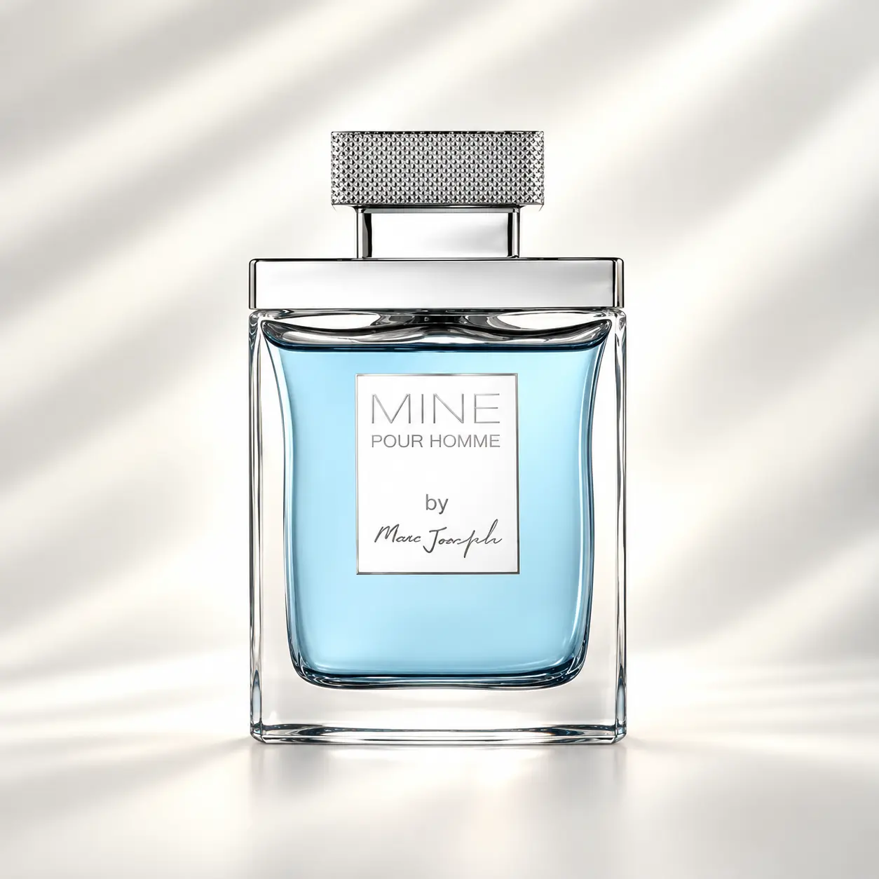 عطر ماین پور هوم مارک جوزف مردانه با شیشه آبی بطری عطر ماین پور هوم مارک جوزف با مایع آبی روشن، شیشه شفاف و درپوش نقرهای