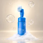 تونیک فومی سپی پور Scalpy Bubble Tonic در میان کف سفید با حباب‌های شفاف و اپلیکاتور برس‌دار
